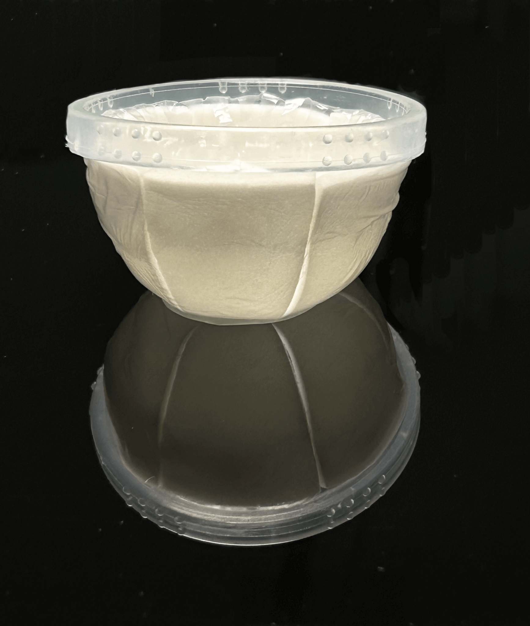 Anu_absorbent_menstrual_disc_sitting_up_on_black_reflective_surface